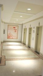 Common corridor with original tile floors, elevators, and artwork at 15 Maiden Lane.