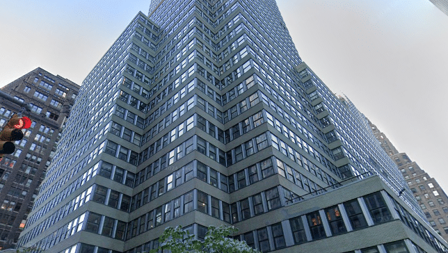 Modern office building at 1407 Broadway, Midtown Manhattan, with a sleek glass-and-steel façade and distinct zigzag corners.