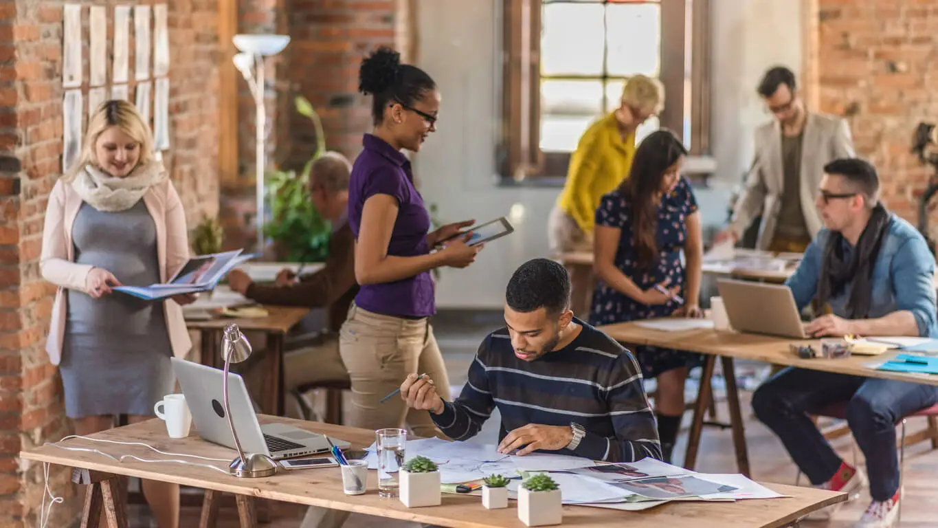 A Group of Coworkers Working in a Stylish Office Room with Desks and Computers.