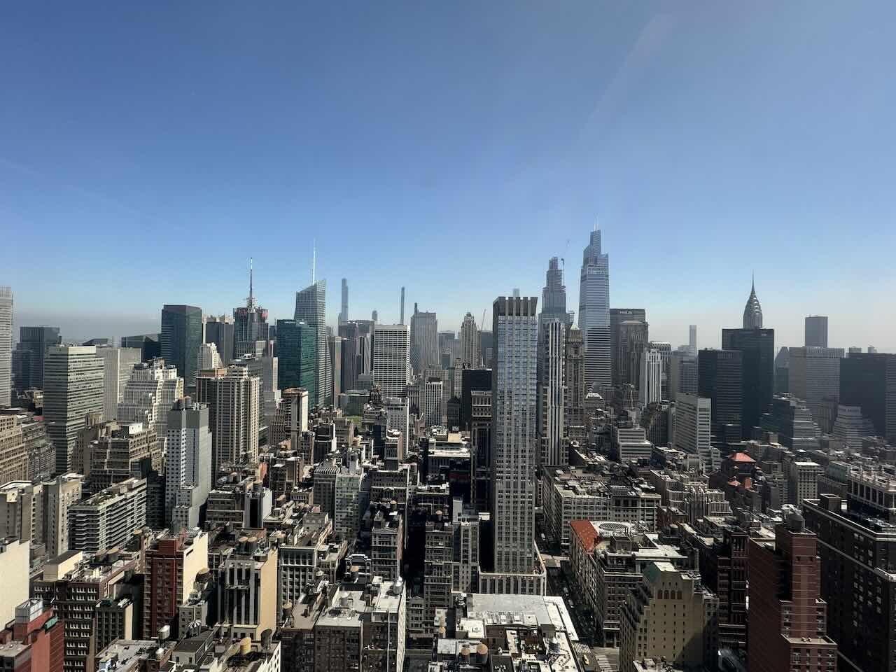 A panoramic view of a New York City skyline featuring the Empire State Building.