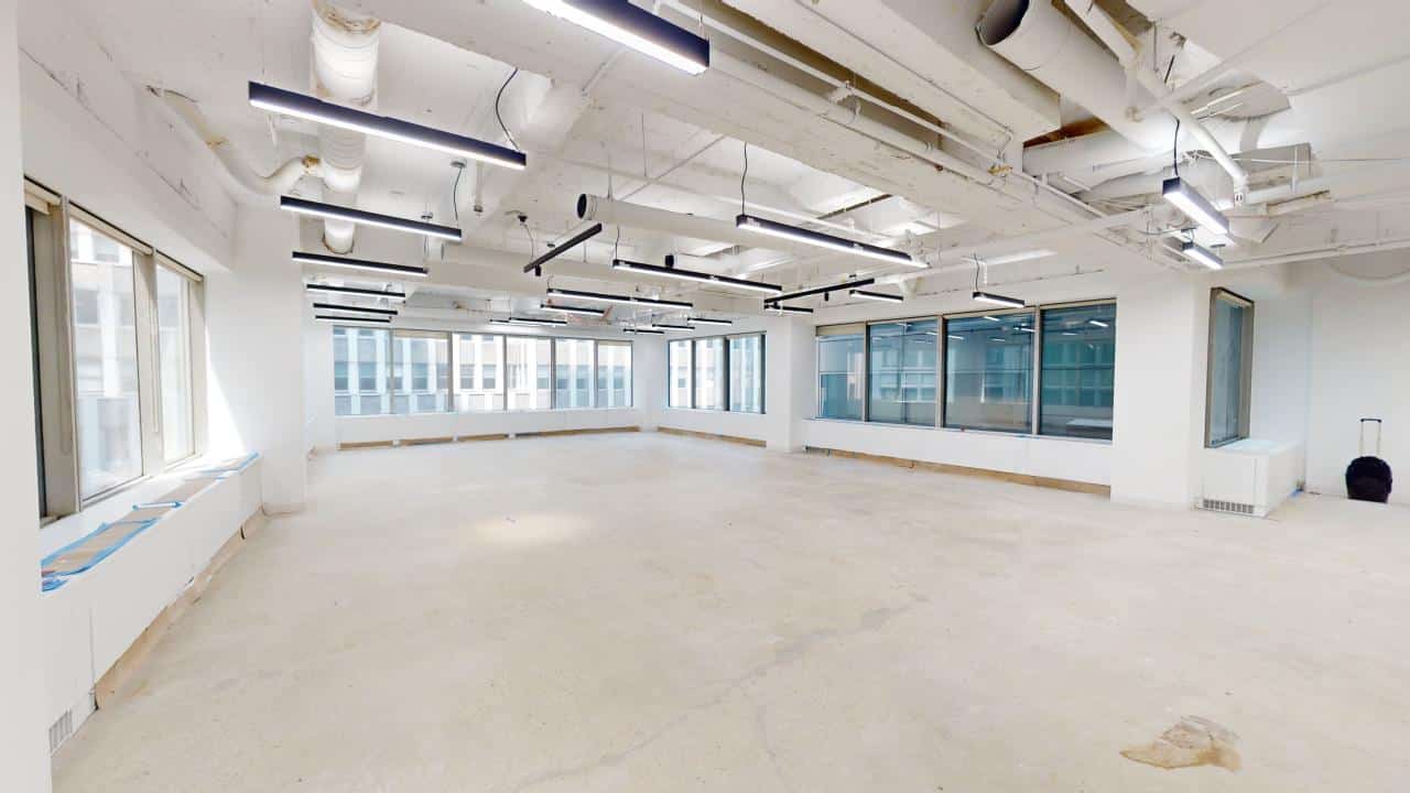 White box office with oversized windows and exposed ceiling beams.