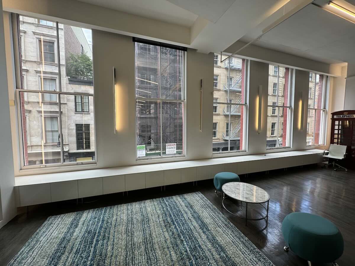 Modern room with large windows overlooking cityscape at 451 Broadway.