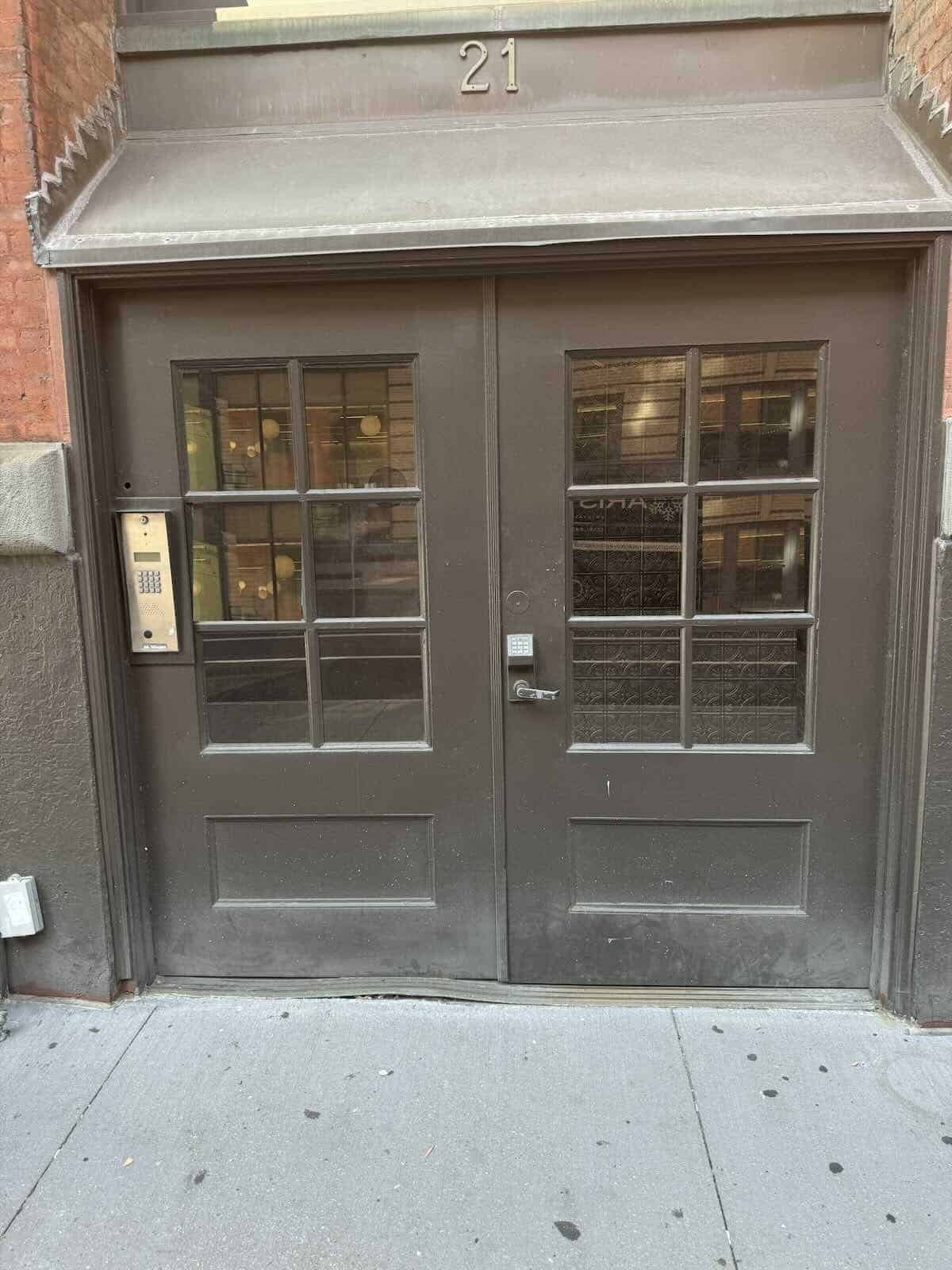 Dark gray double doors with glass panes, brick building