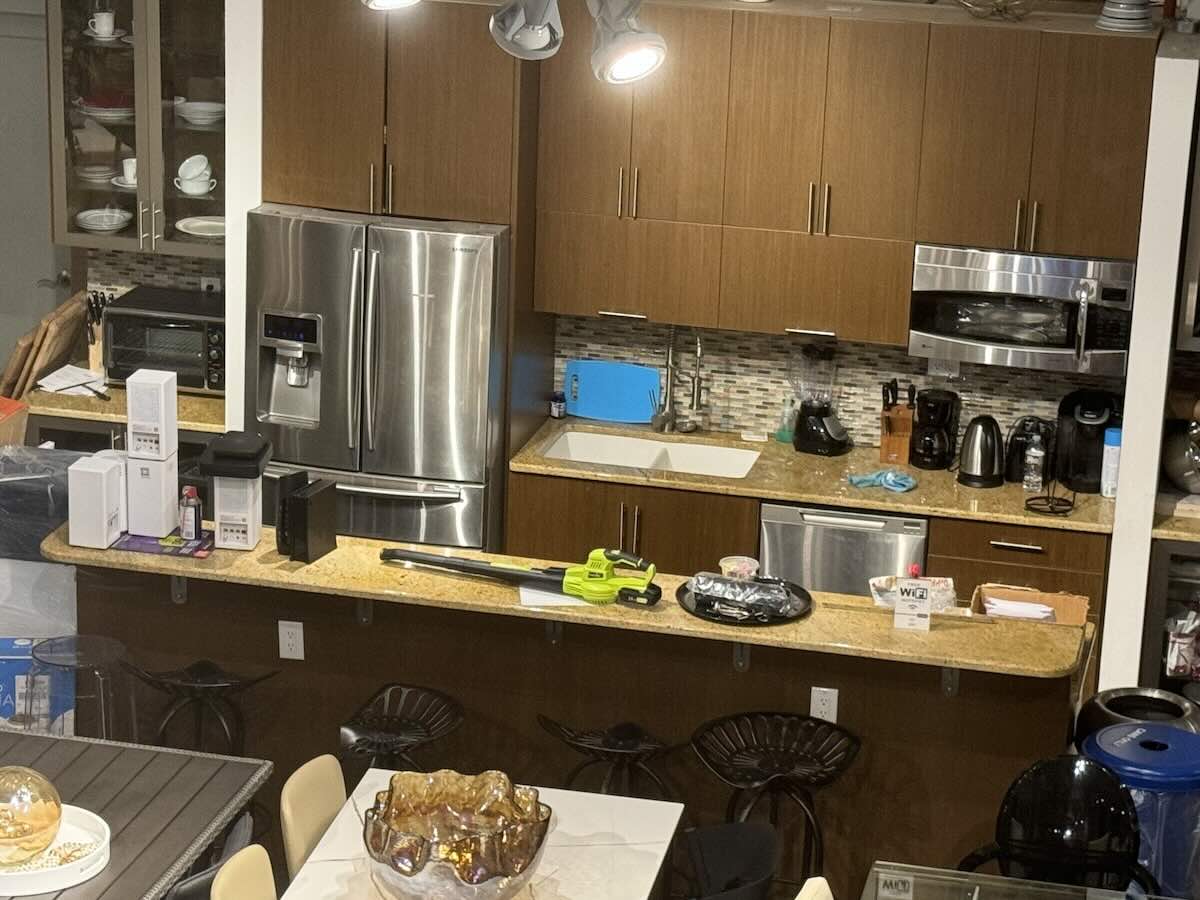 A cluttered kitchen at 44 West 24th Street with brown cabinets.