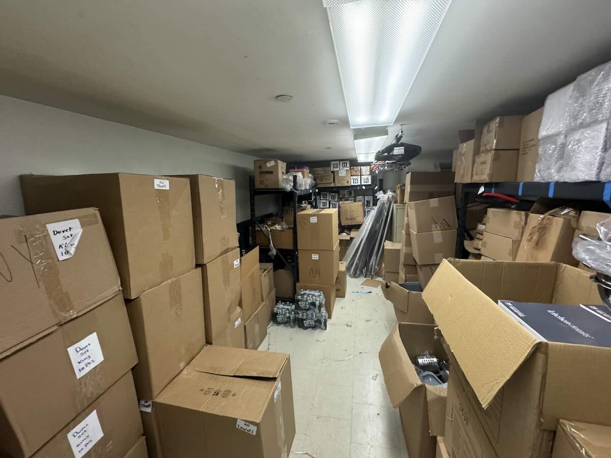 Storage room at 44 West 24th St with stacked labeled cardboard boxes.