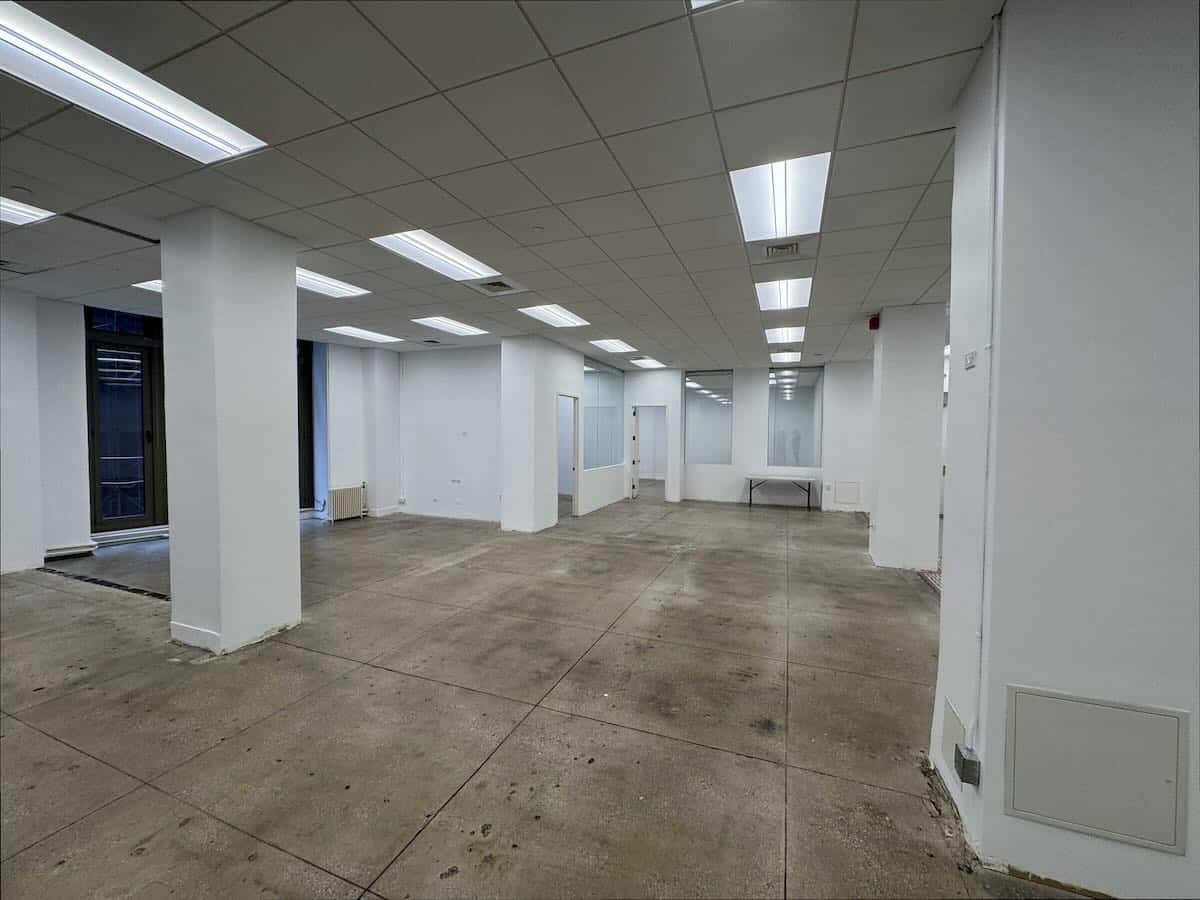 A large, empty office space with white walls and pillars.