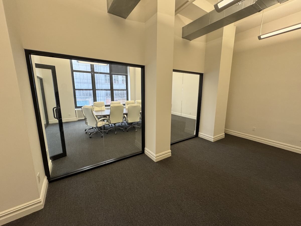 Spacious modern office with large windows and high ceilings.