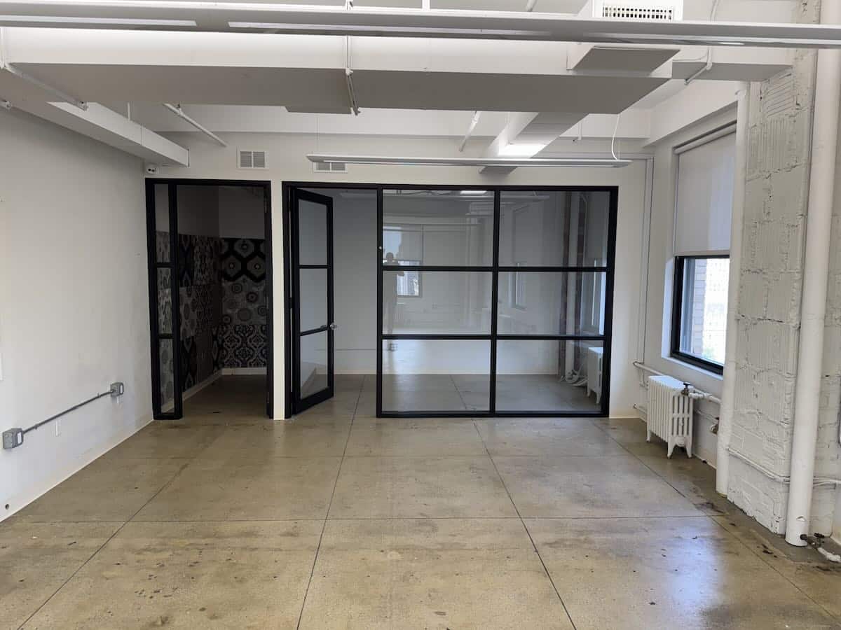 Spacious, empty office with large windows and polished concrete floors.