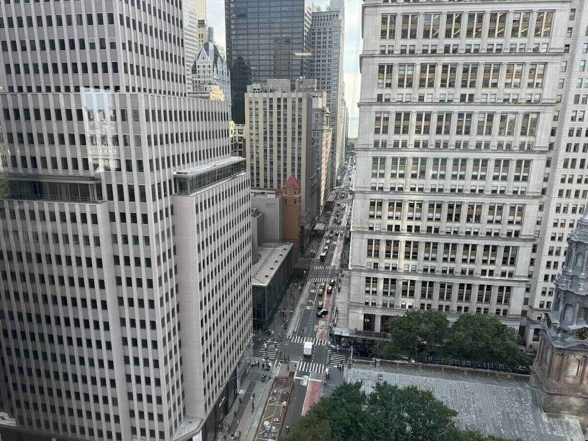 Broadway bustling with vehicles, pedestrians, and office buildings.