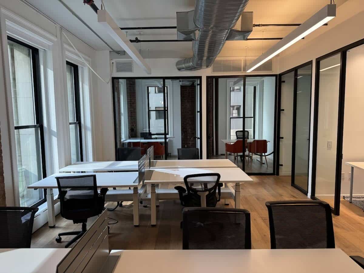 Open office space at 111 Broadway with empty workstations, white desks, and chairs.