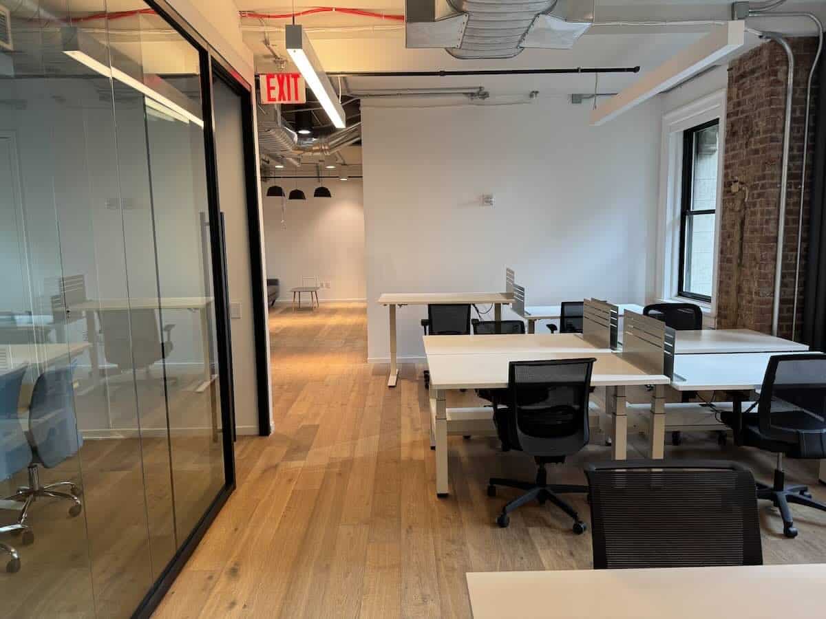 A modern office at 111 Broadway with light wood floors, large windows.