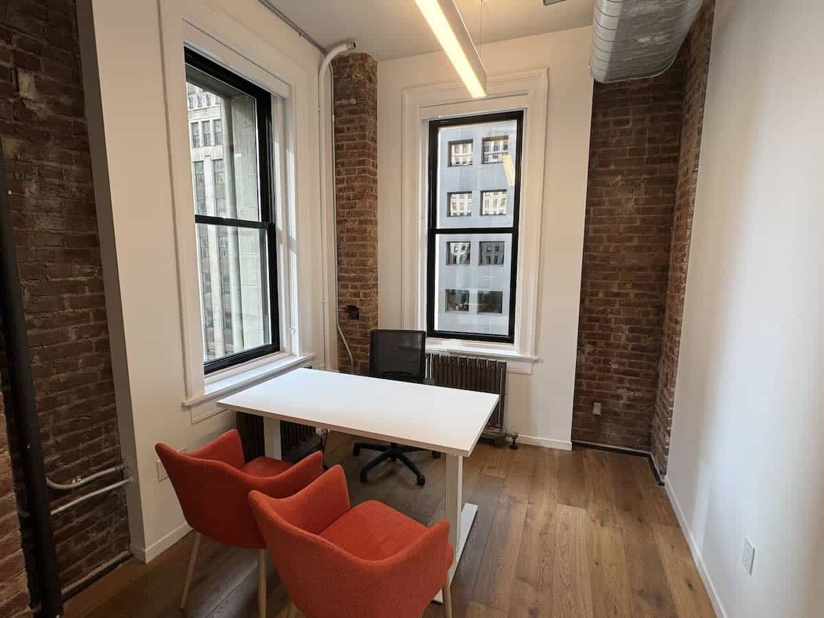 A modern office at 111 Broadway with brick walls and city views.