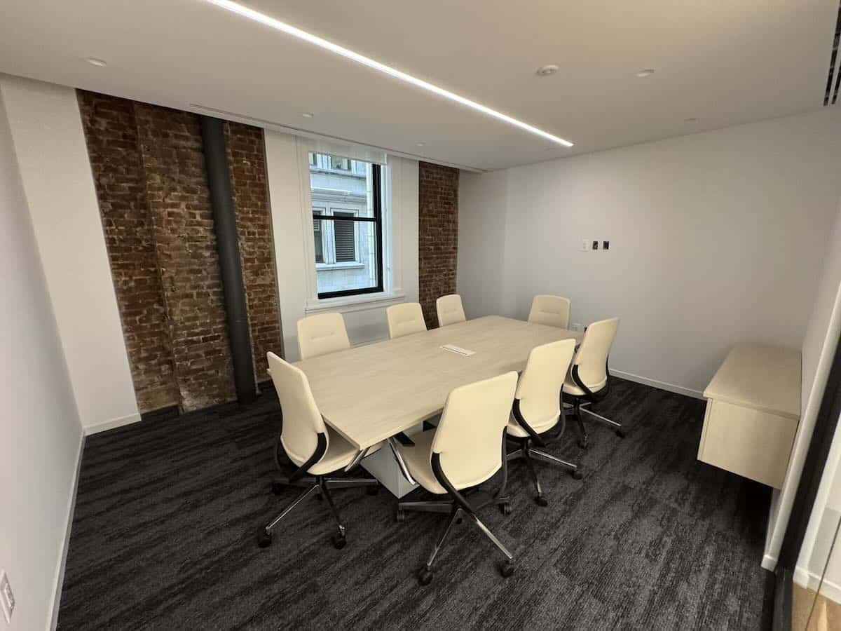 Modern conference room with wooden table and white chairs