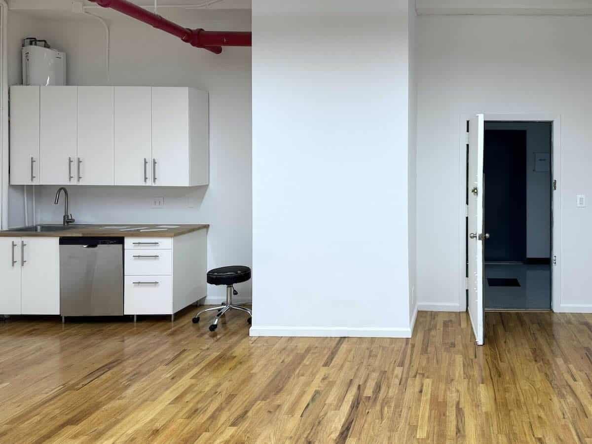 A minimalist room with wooden flooring and a wet pantry