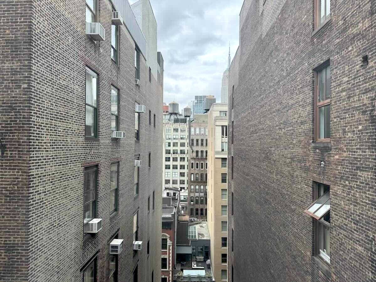 Urban alley view with brick buildings, windows, A/C units