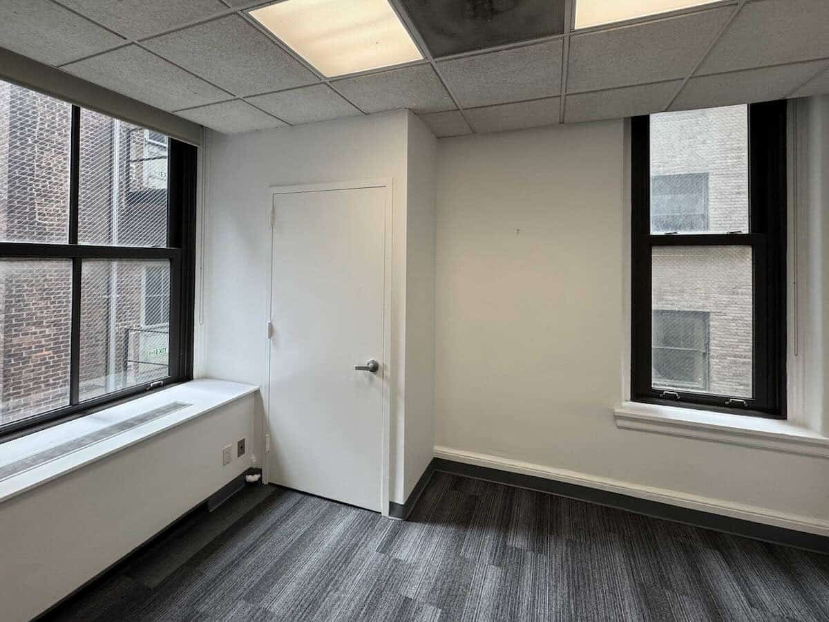 Suite 806 at 18 E 41st Street with two large windows and white walls.