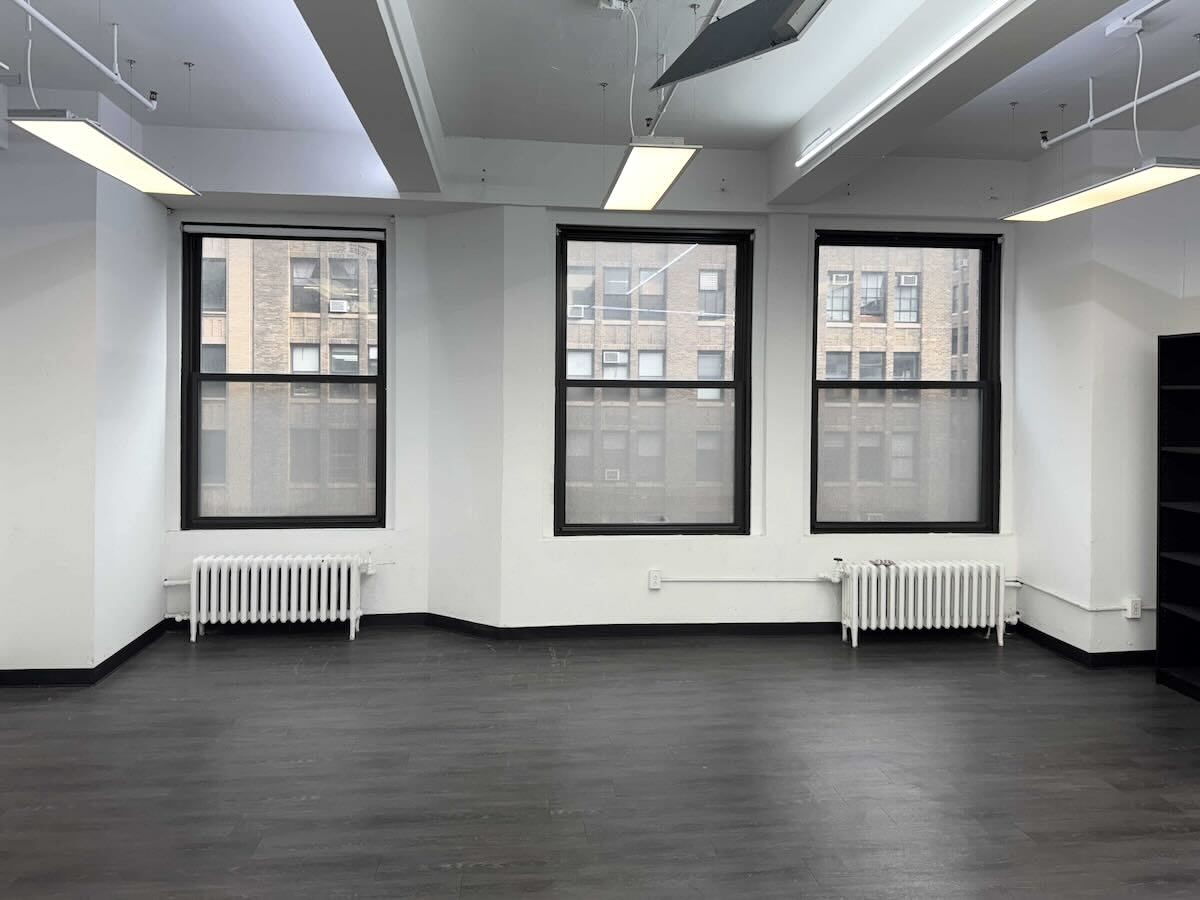 Empty room with dark floor & black-framed windows