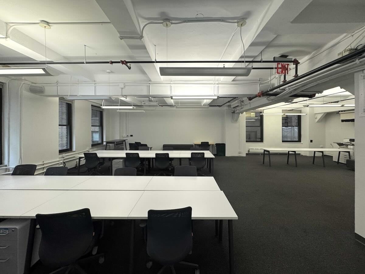 Bright office on Madison Ave with white desks and large windows.