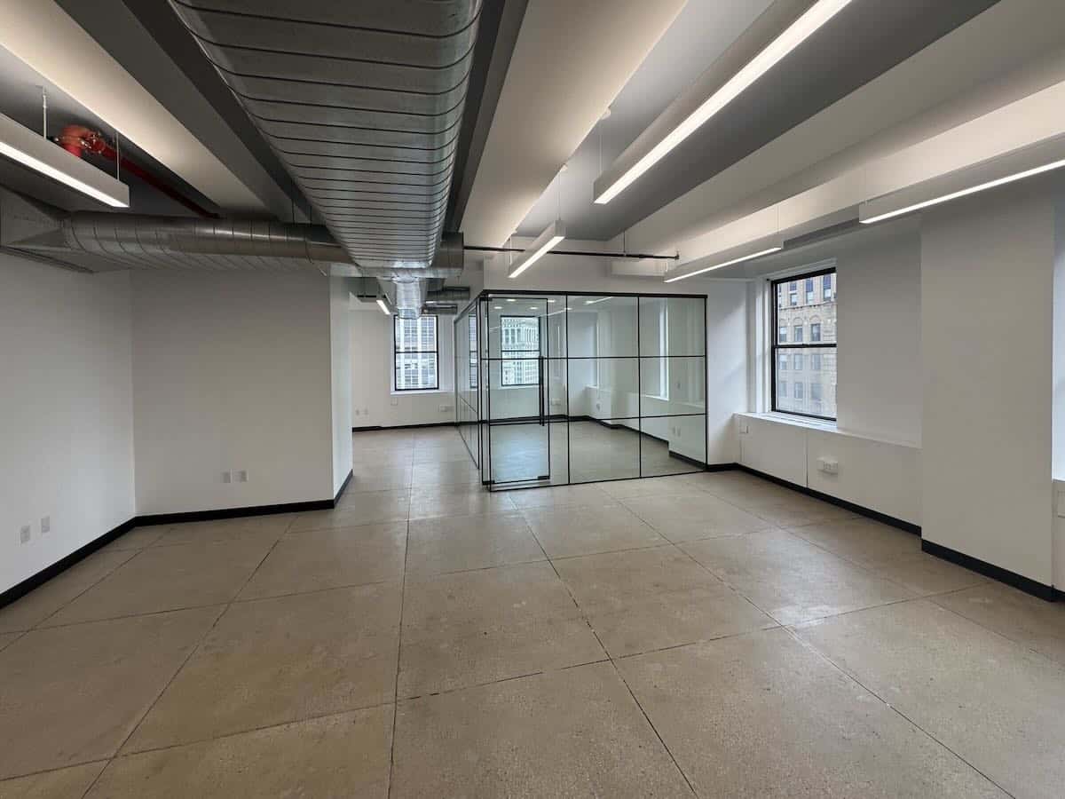 Empty office with white walls, large windows, and modern finishes.