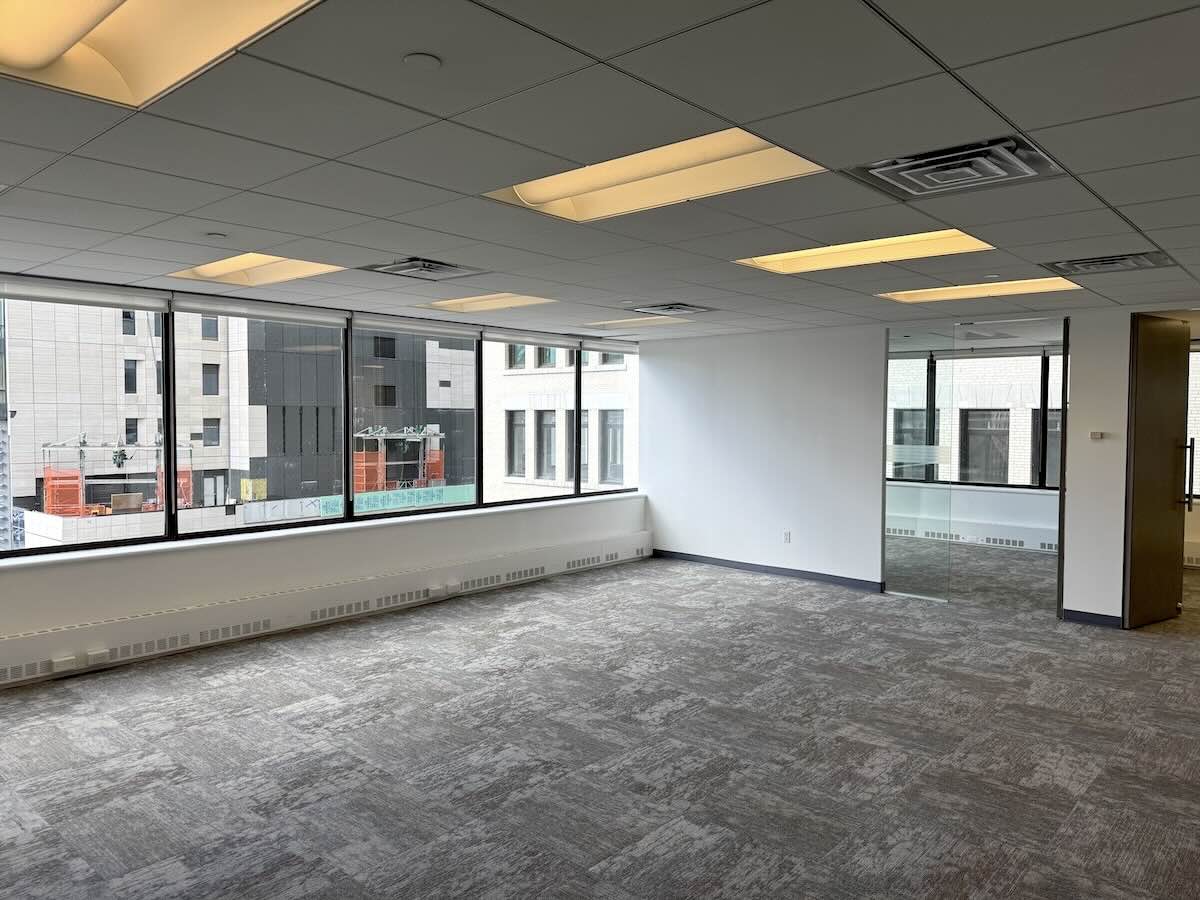 Office with large windows and gray carpet on 9th floor.