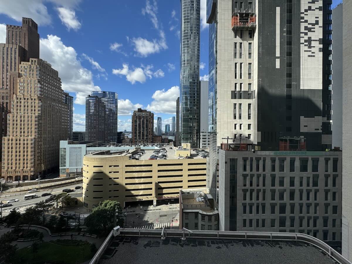 Modern cityscape with high-rise buildings under a cloudy blue sky