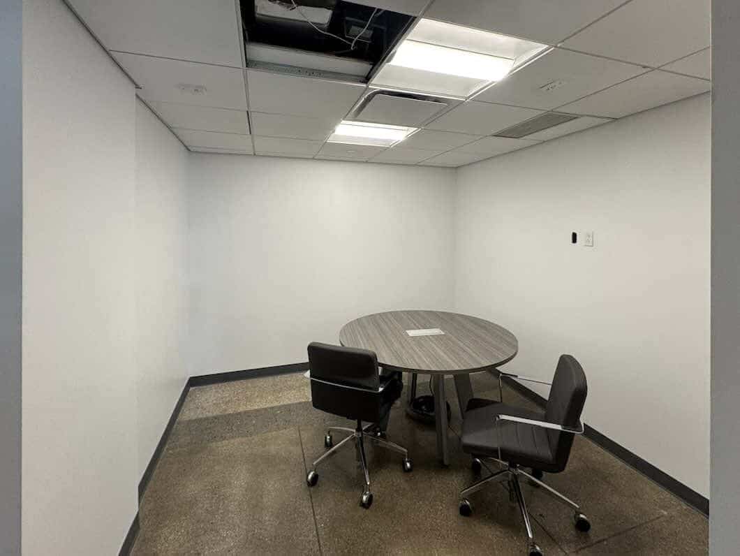 Unfurnished office at 50 Broad St with table and two chairs.