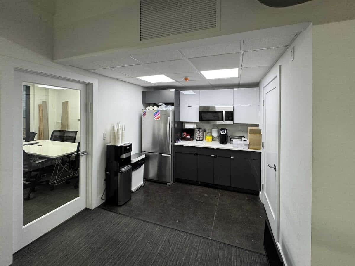 Office kitchenette with stainless fridge and modern conference room.