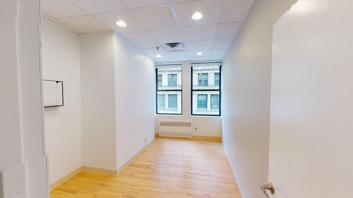 Empty office at 928 Broadway with wooden floor and natural light.