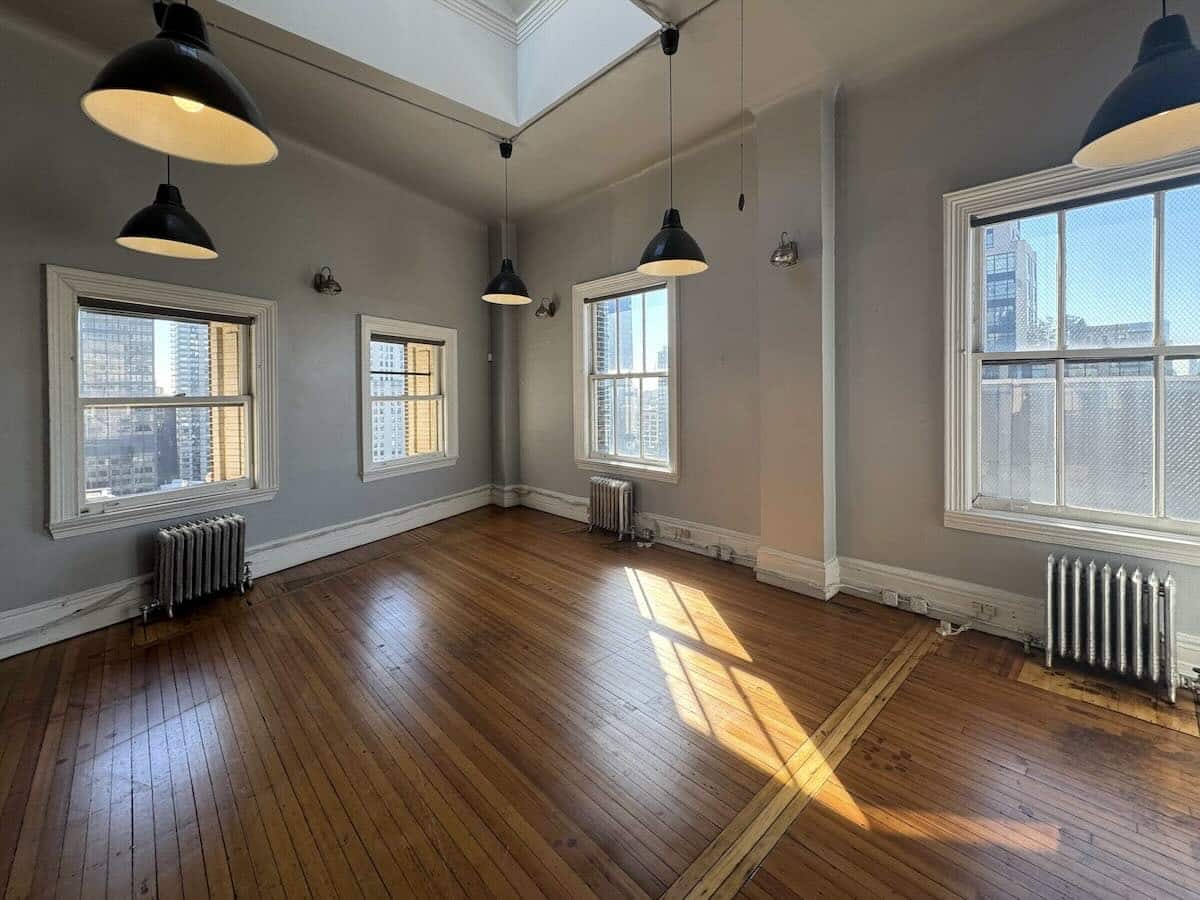 Sunny room with wood floors, large windows, and minimalist décor at 1133 Broadway, #1625