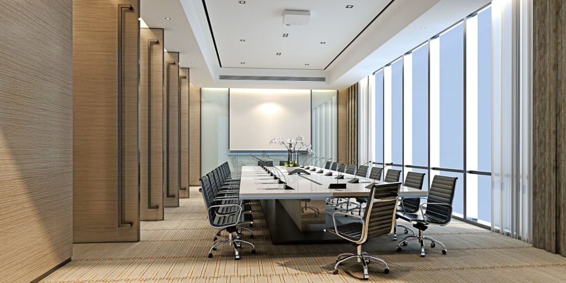 Modern conference room with table, chairs, windows, and projector screen.