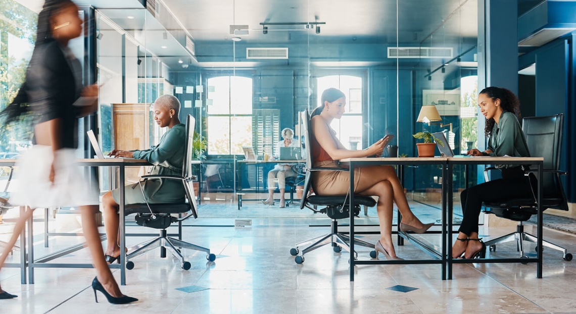 Modern law office with glass walls and people working at desks.