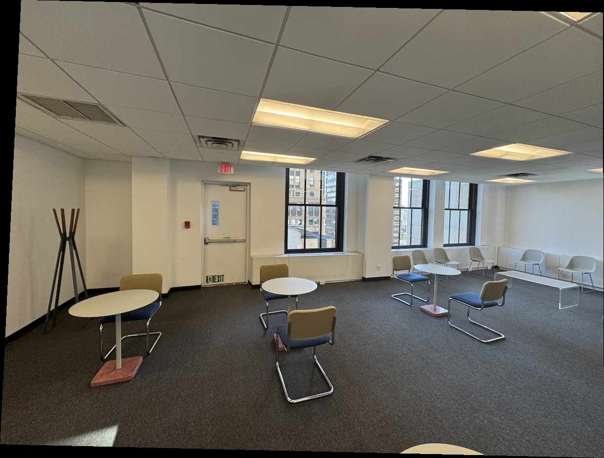 Office room with tables, chairs, windows, and coat rack.