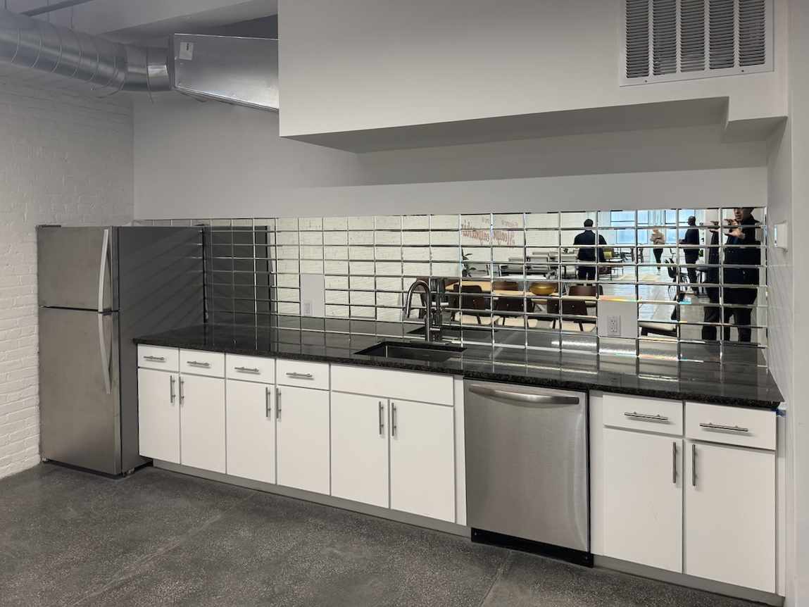 Modern kitchen with white cabinets and stainless steel appliances.