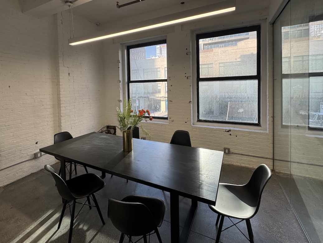 Modern conference room with sleek table and large windows.