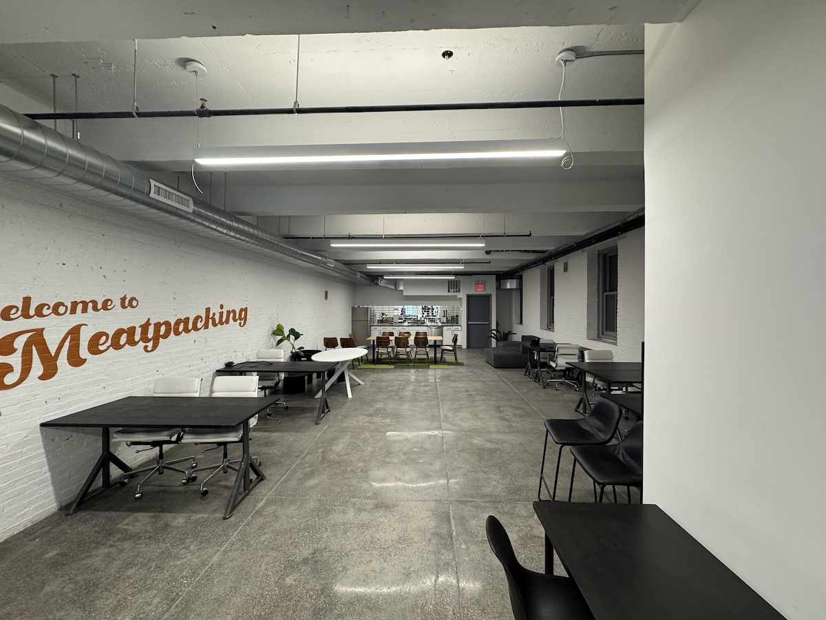 Industrial office: concrete floors, white brick, black desks.