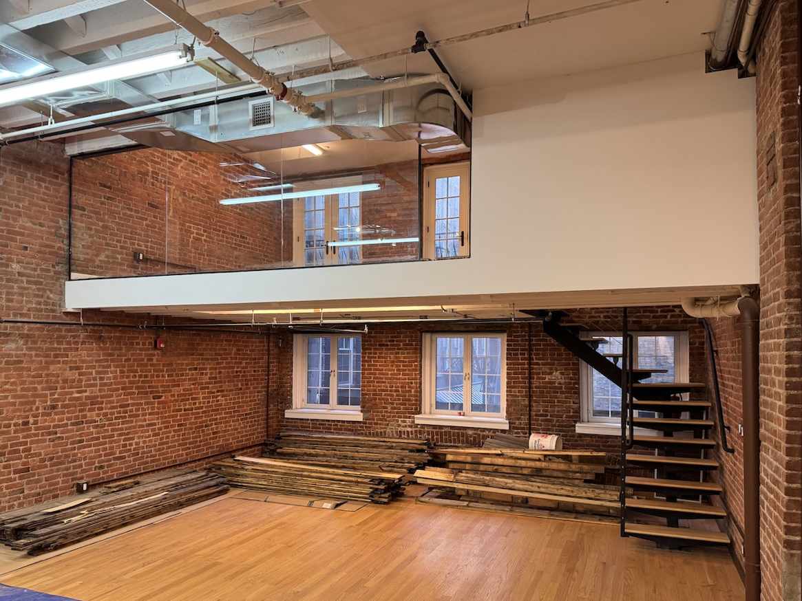 Broome Street interior: brick walls, wood floor, mezzanine, staircase.