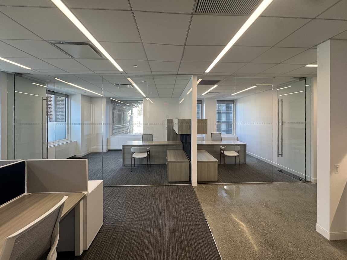 Modern office at 152 West 57th Street with glass walls and neutral tones.